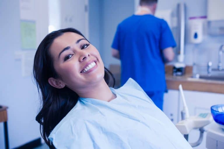 Dentist performing teeth whitening and dental implant procedures at Midland Dental Hub, helping patients to achieve a brighter smile and restore missing teeth for optimal oral health and confidence